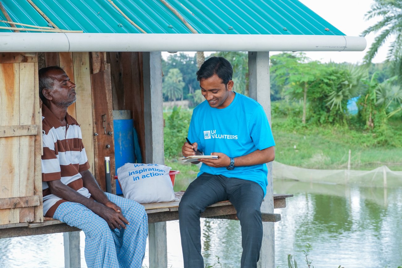A UN Volunteer speaks to a local community member in Bangladesh.
