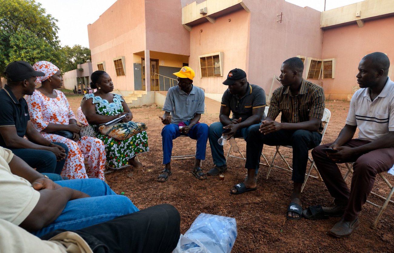 Un volontaire des Nations Unies s'entretient avec des membres de la communauté locale au Burkina Faso.