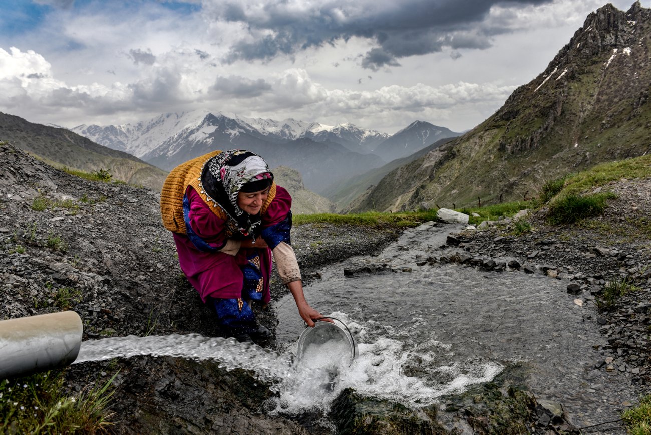 A woman in Türkiye fills a pot with water.