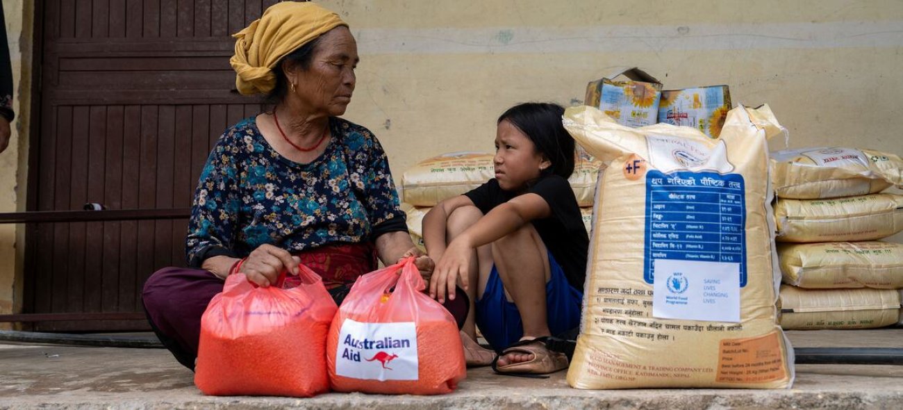 A woman and a child receive aid following floods in Nepal.