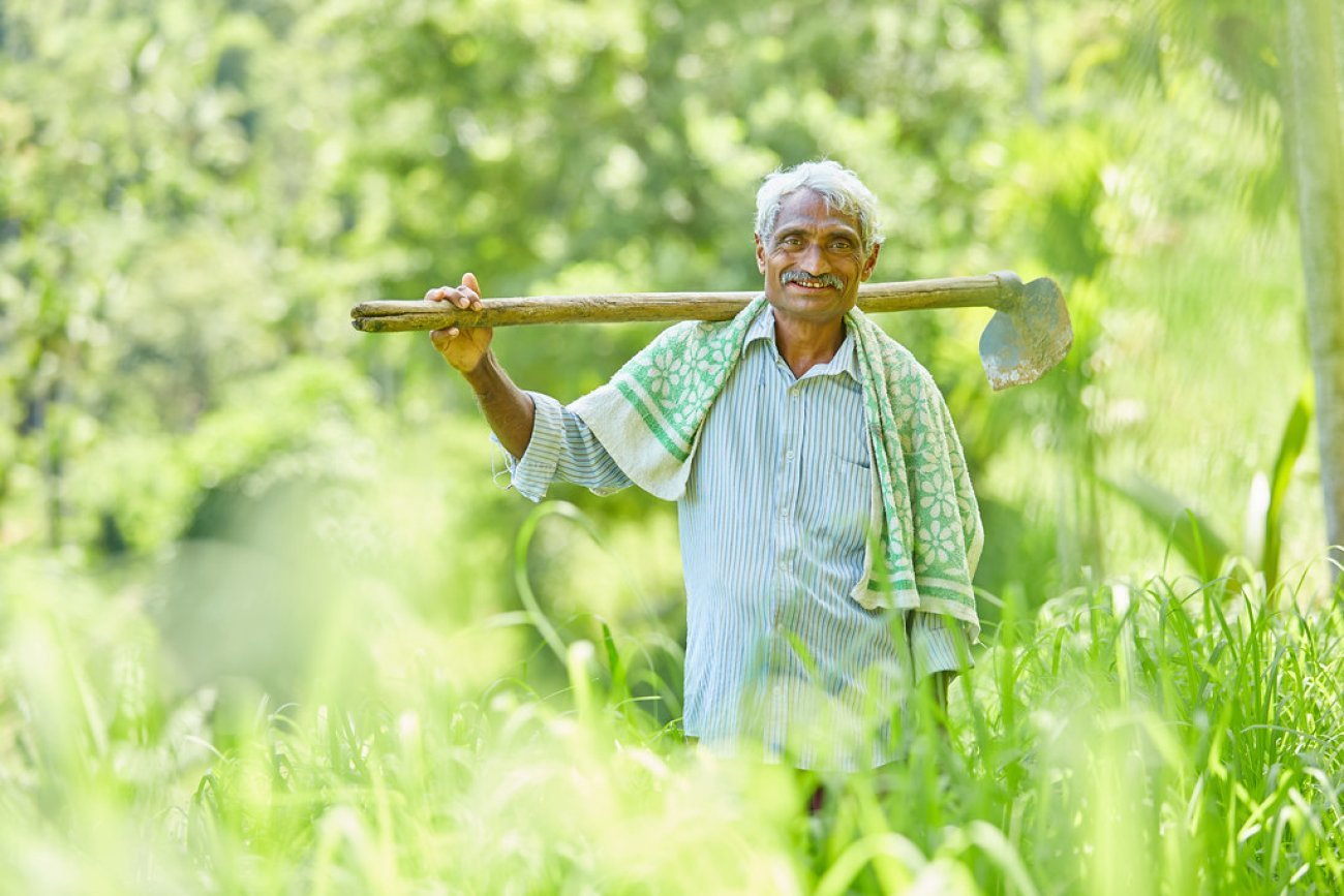 Farmer carries a tool in a field