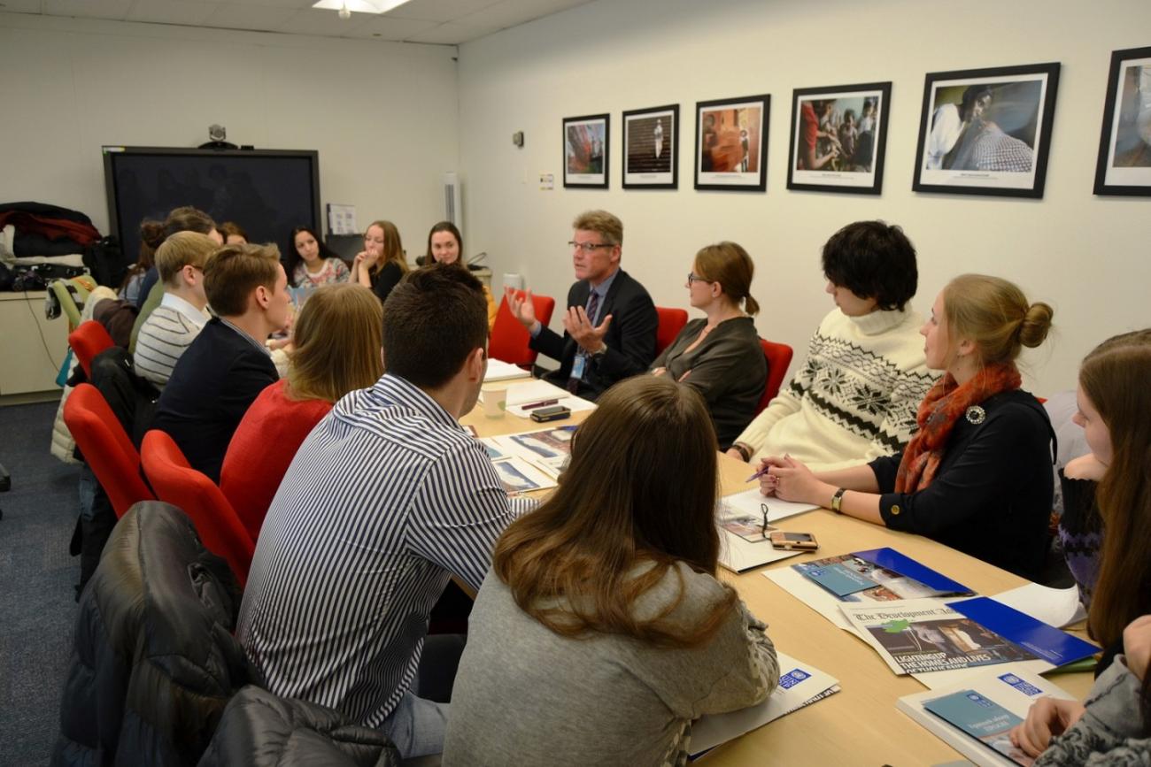 An image of several people around a boardroom table having a meeting. 