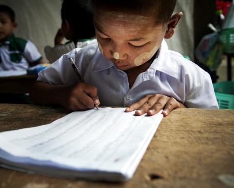 Un enfant s'entraîne à écrire dans une classe de maternelle, à Tachilek, au Myanmar.