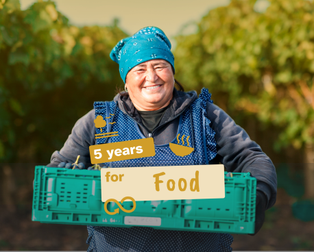 An image of a woman with a crate of fruits and vegetables