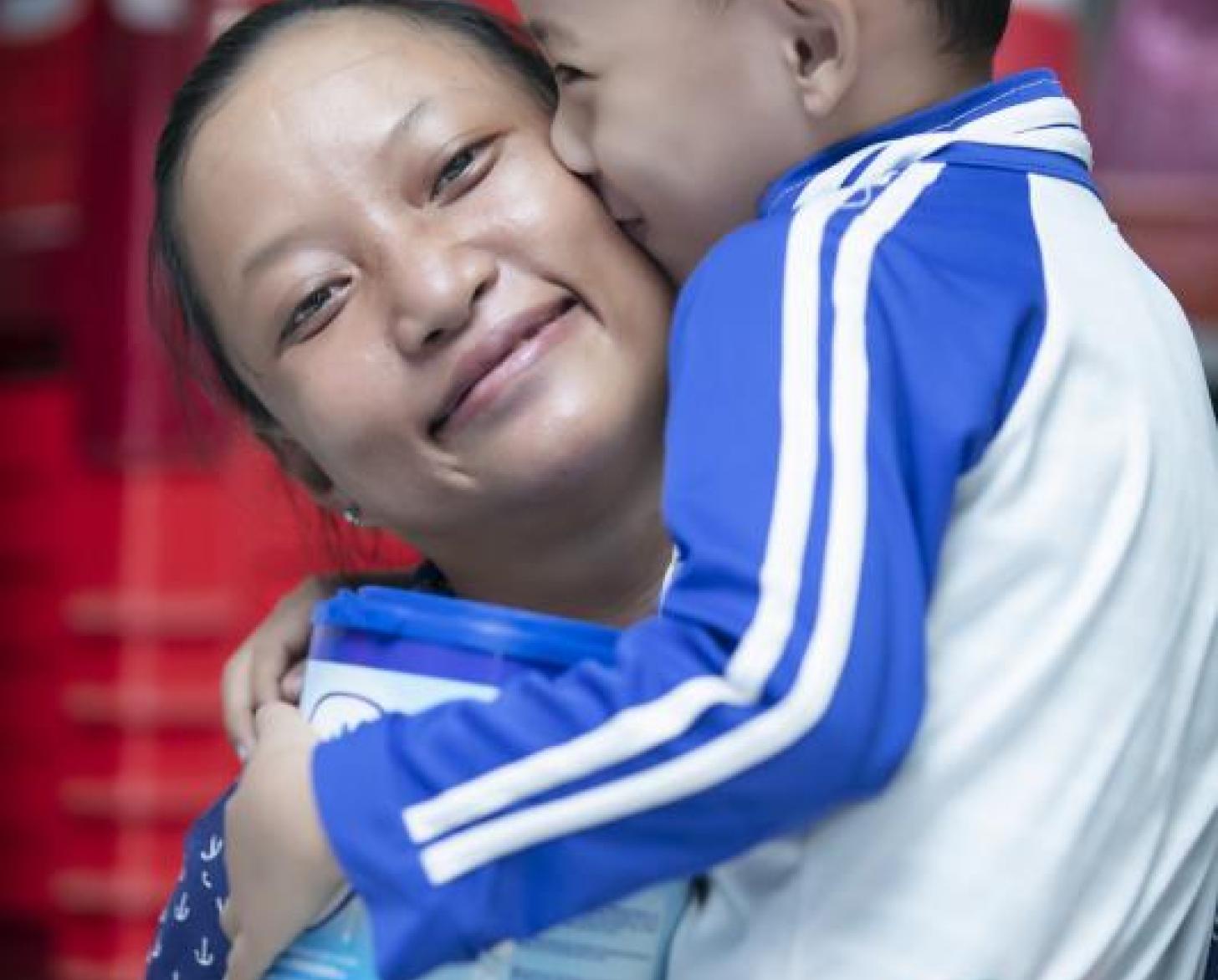 تشاو باو تبتسم بسعادة بالغة وهي تحمل ابنها.