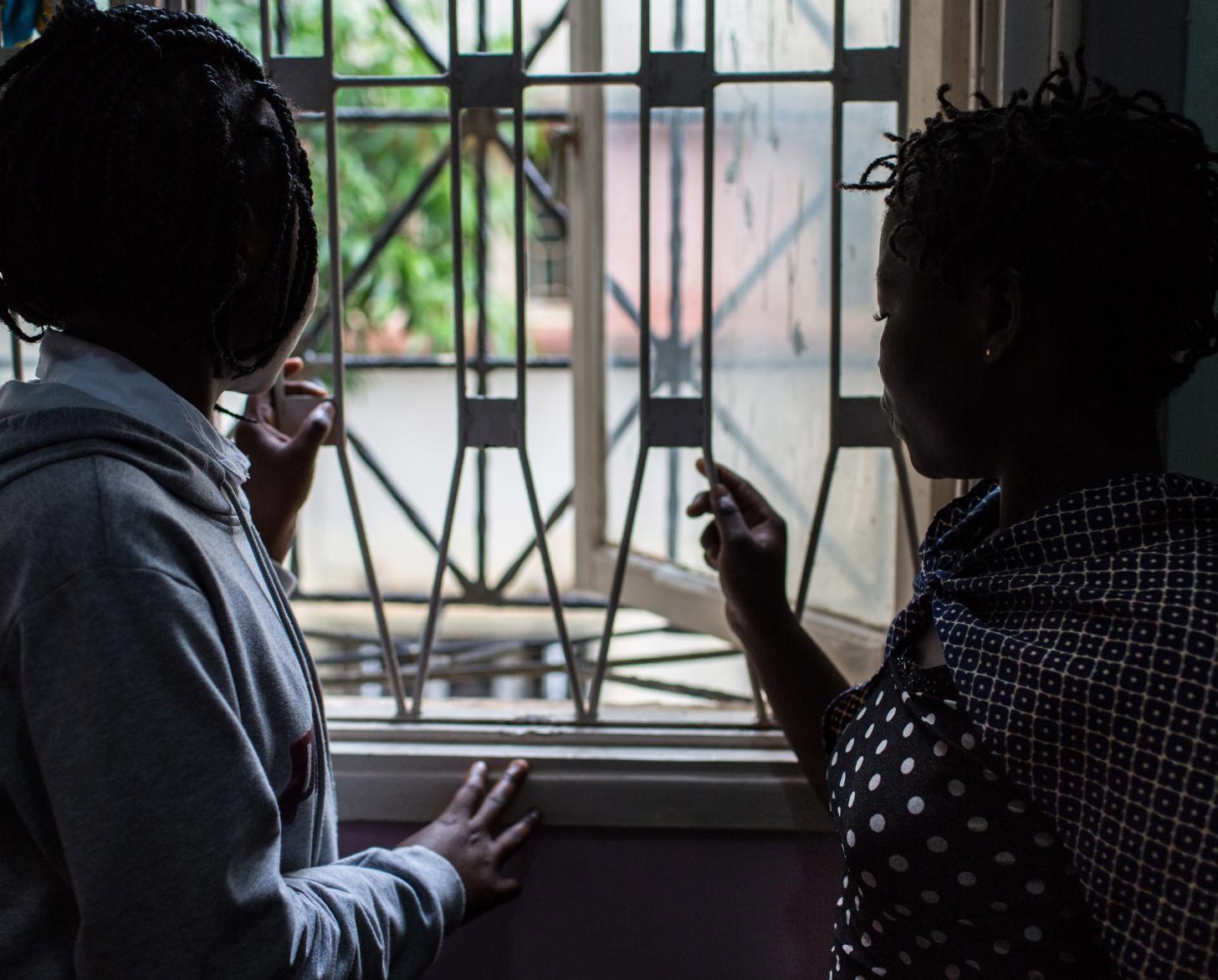 Two survivors of violence look outside a window at the offices of a non-governmental organization in Nampula. 