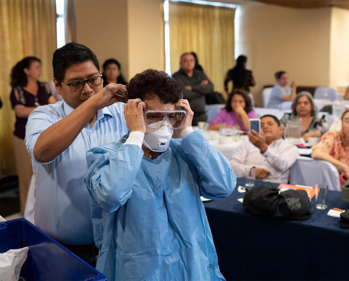 Men demonstrate how to properly put on protective gear.