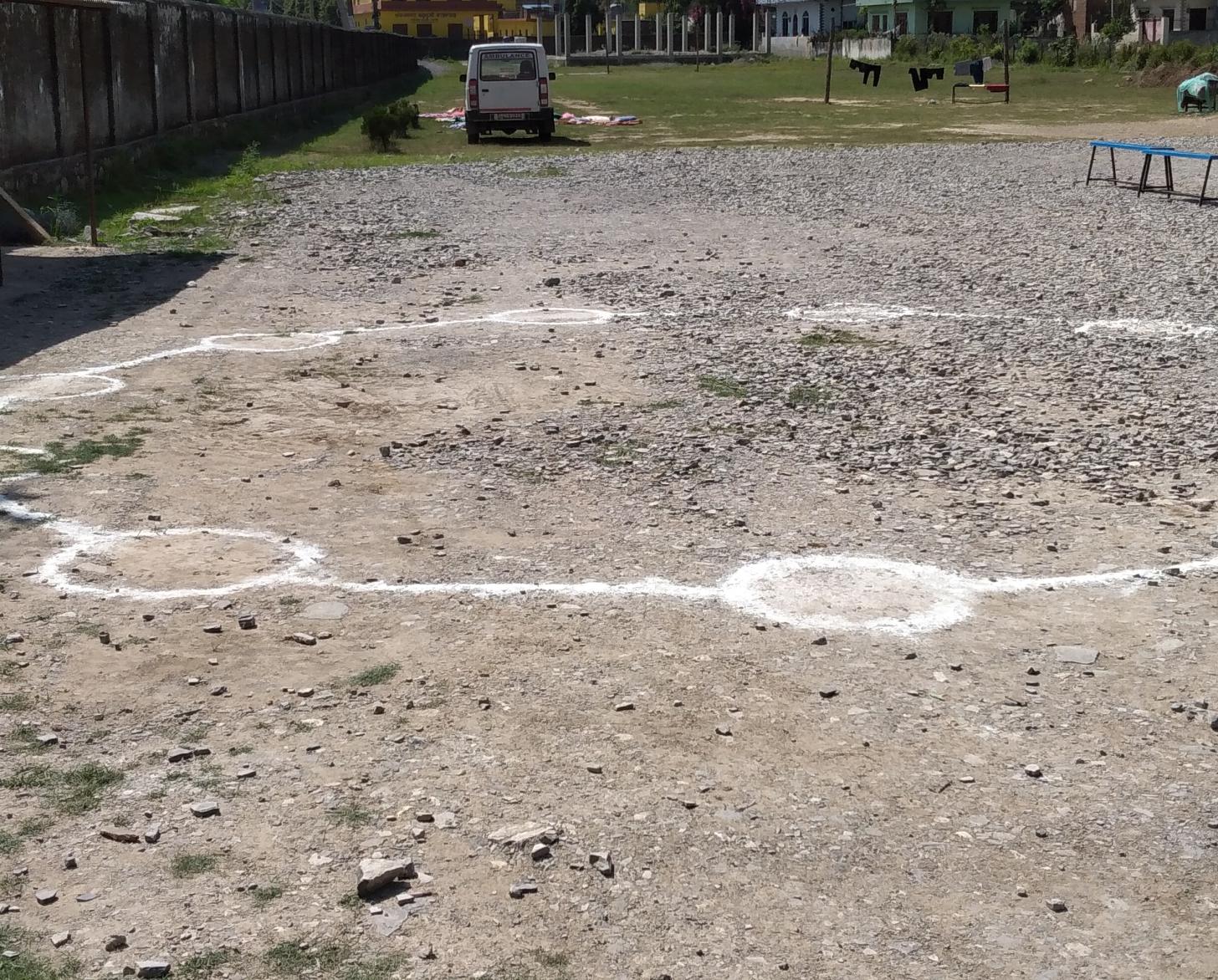 تم رسم الدوائر على الأرض لمساعدة العاملين الصحيين في الحفاظ على مسافة آمنة بين بعضهم البعض في مركز الحجر الصحي في منطقة روبانديهي في غرب نيبال.