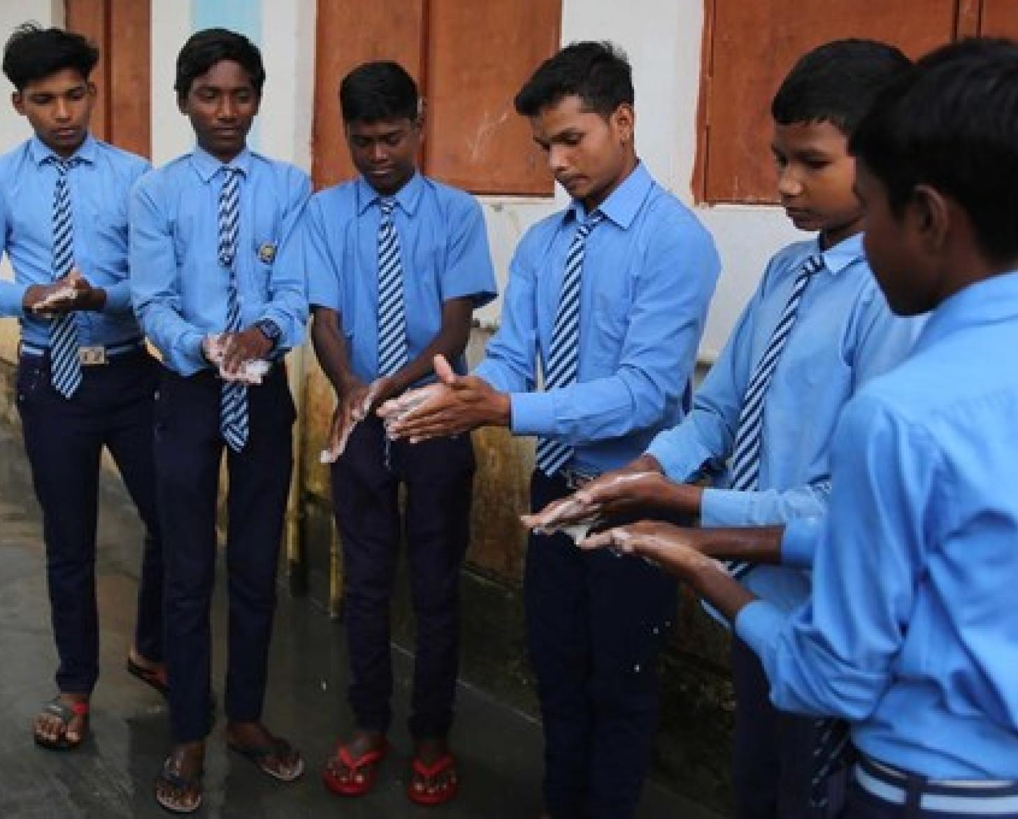 Alumnos de una escuela de Chhattisgarh, en el noreste de la India, practican técnicas seguras de lavado de manos.