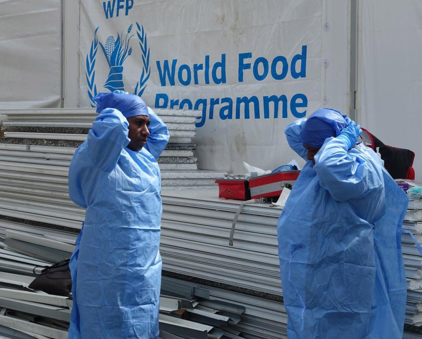 Los trabajadores sanitarios de NCD practican la colocación del EPI antes de un simulacro para los medios de comunicación y los invitados en una instalación de pruebas y aislamiento de la COVID-19 en Port Moresby.