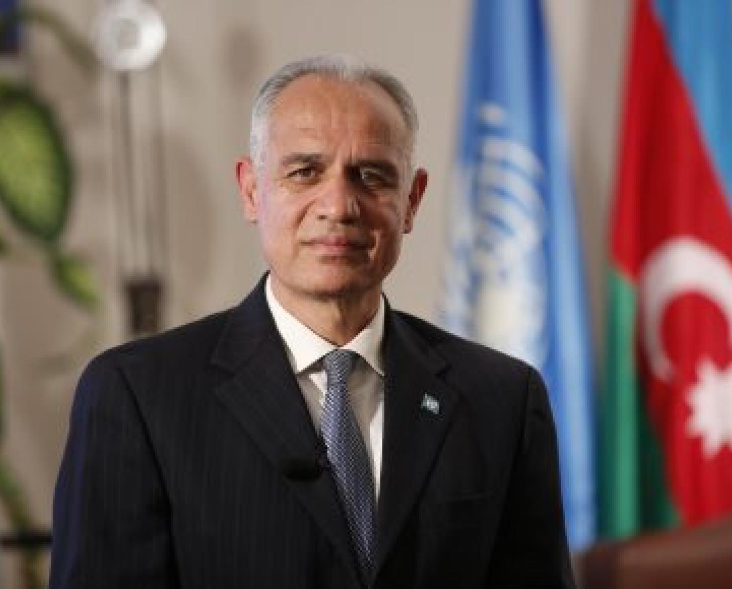 Foto oficial del Coordinador Residente, Ghulam M, Isaczai, delante de la bandera de la ONU y de Azerbaiyán.