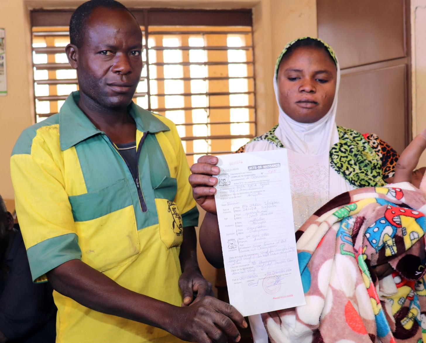 After an arduous process, Safiatou and her husband Idrissou receive their newborn's birth certificate.