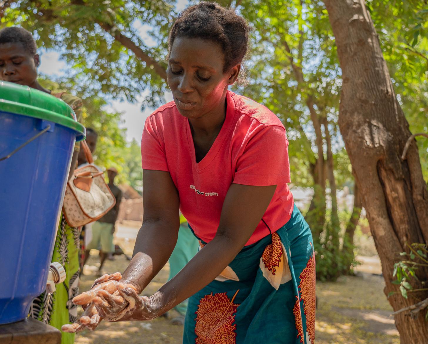 Una mujer utiliza una estación de lavado de manos apoyada por la ONU.