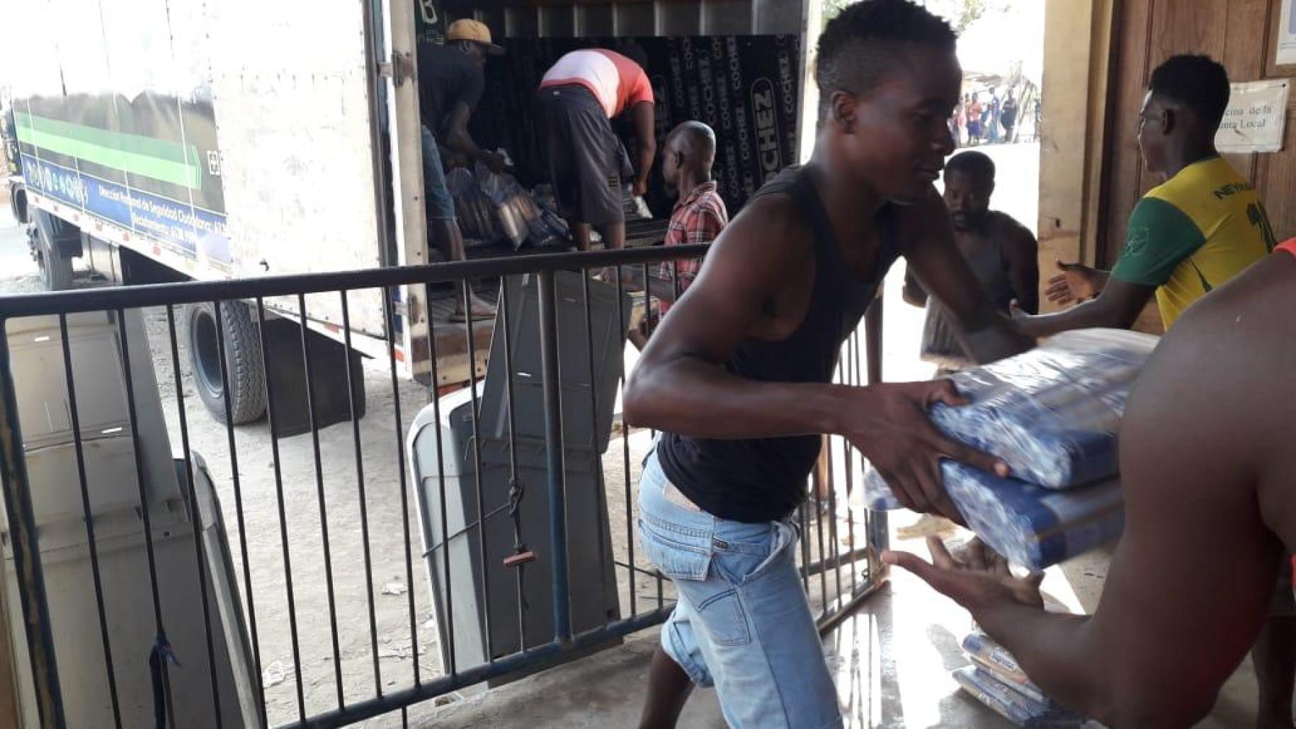 يشكل الفريق خط تجميع لتفريغ الإمدادات الأساسية المتبرع بها لمواجهة الجائحة.