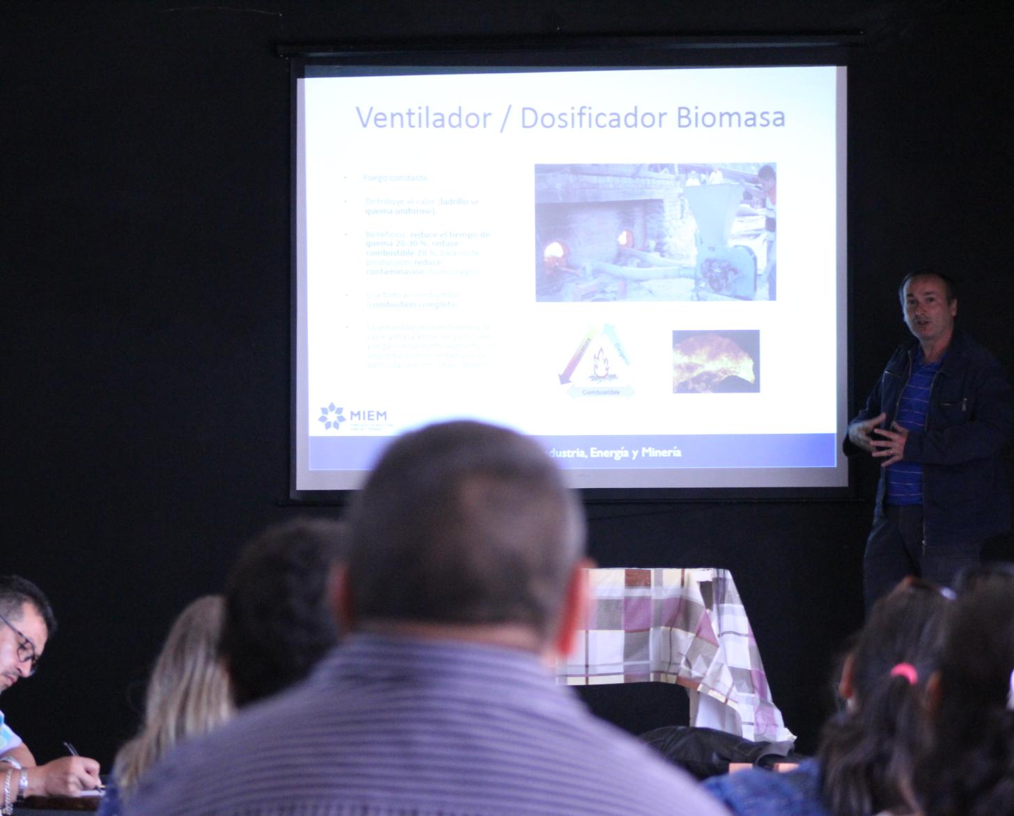 Photo shows a PAGE representative presenting to artisanal brickmakers on how to make better and cleaner bricks more efficiently.