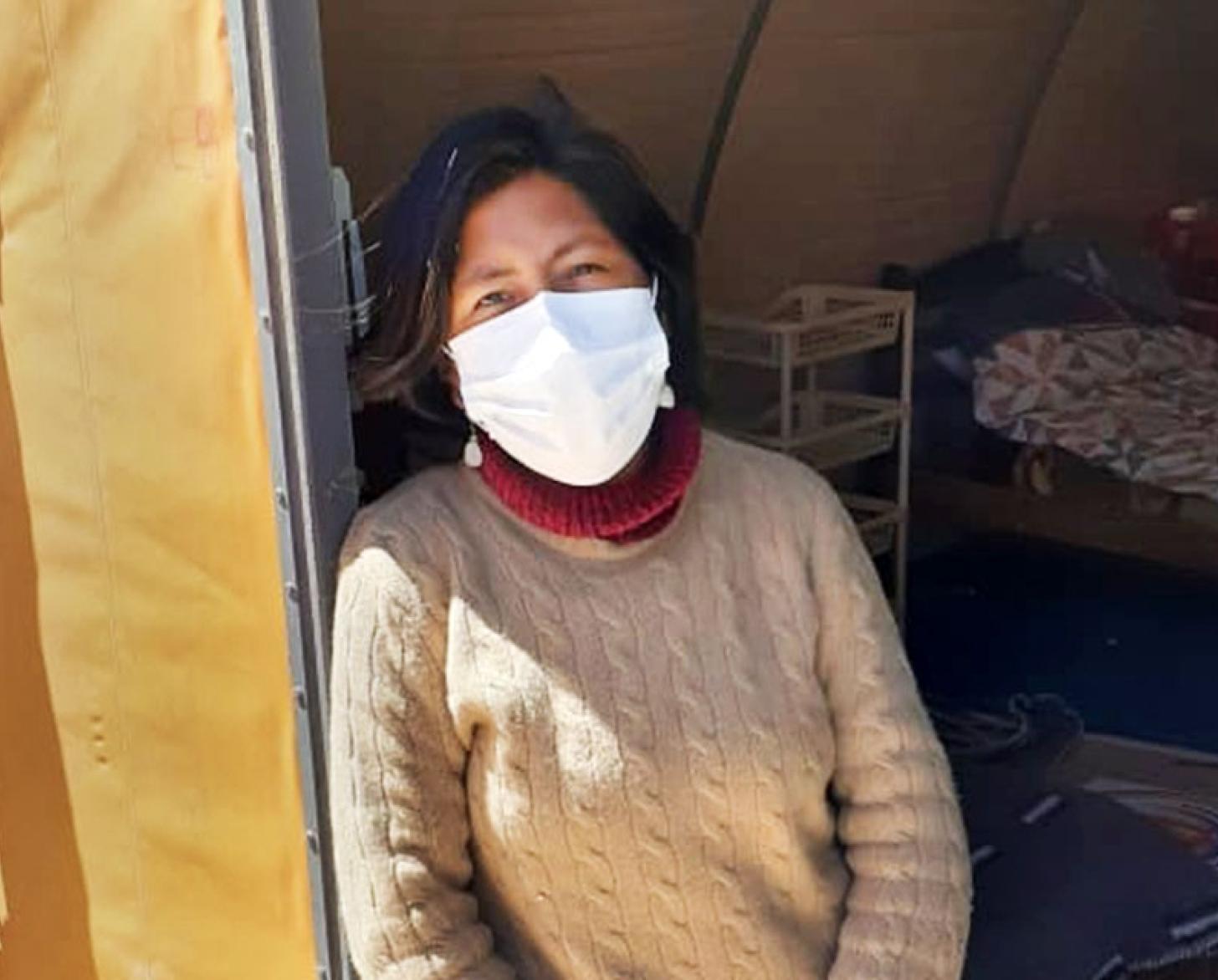 المهاجرة البوليفية مونيكا كويجوا تقف أمام باب غرفتها.