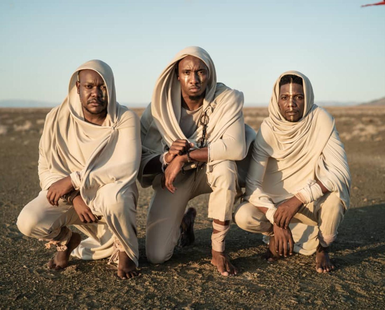 تظهر الفرقة المؤلفة من ثلاثة أشخاص وهي جالسة على الأرض.