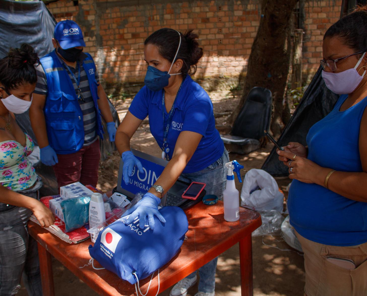 يشرح موظفو المنظمة الدولية للهجرة للمقيمين ما تحتويه كل مجموعة أساسية تم التبرع بها.