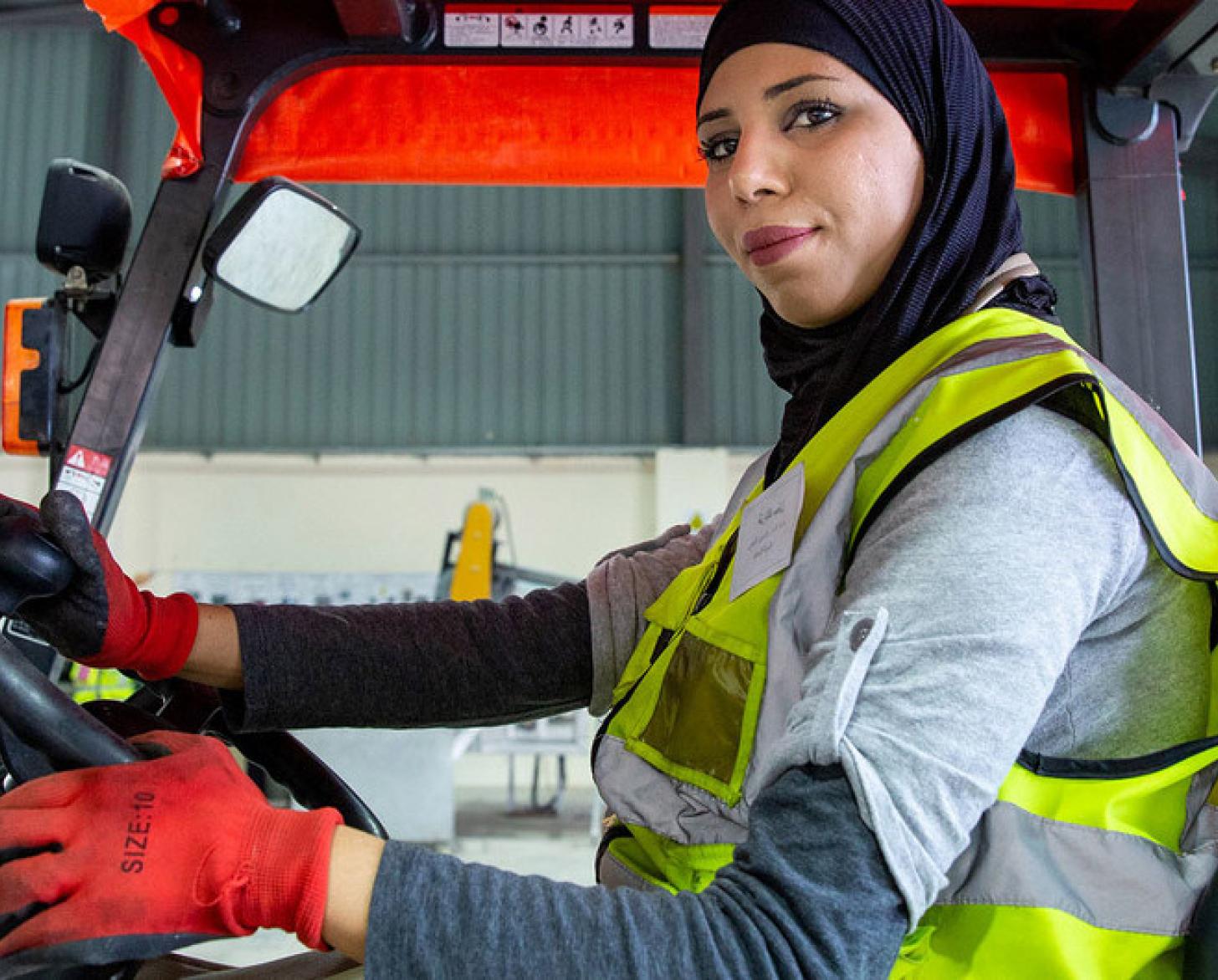 A woman drives a forklift truck at the recycling plant where she works in Northern Shouneh, Jordan.