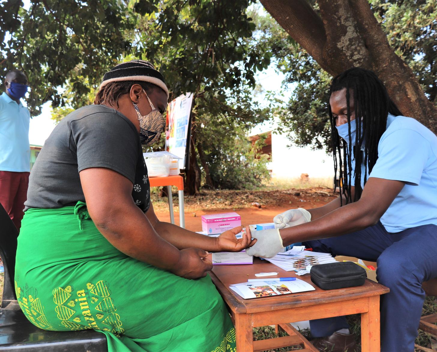 عامل رعاية صحية يجلس أمام طاولة في قبالة امرأة.