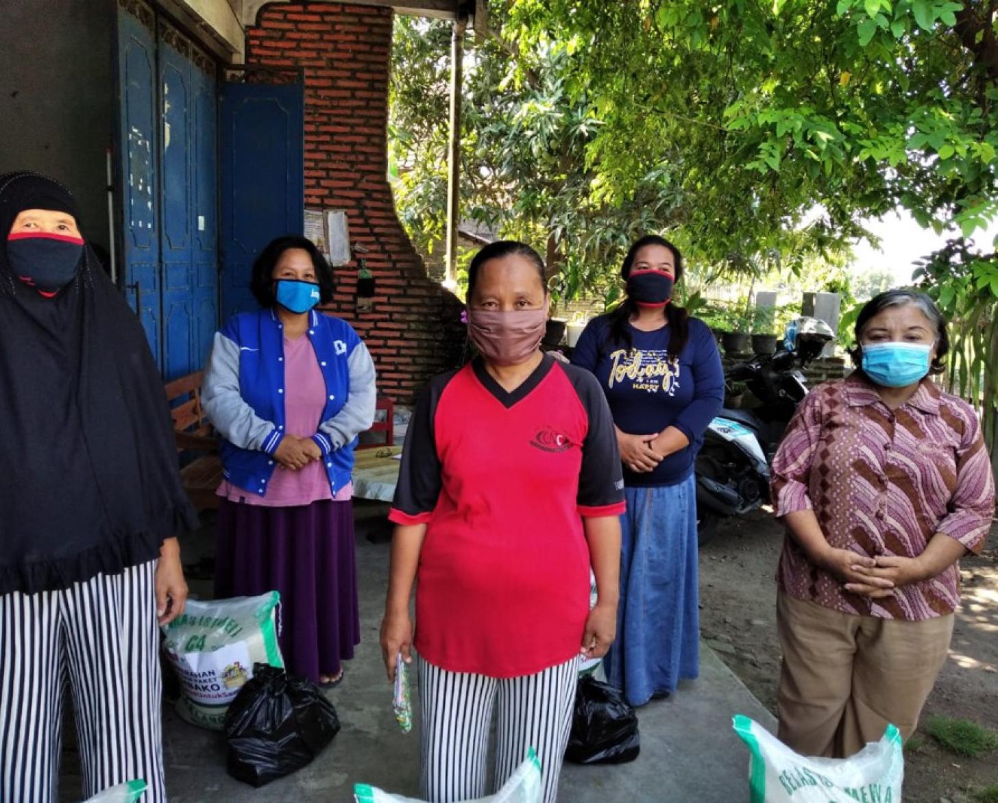 تقف نساء بفخر في قرية السلام في جيتيس، جاوا الوسطى.