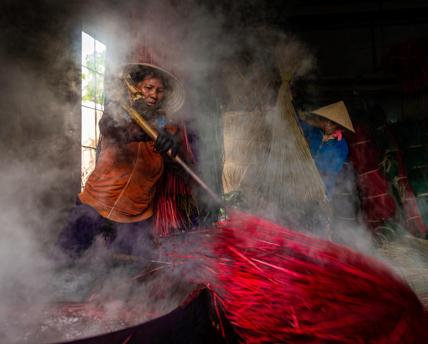 تُظهر الصورة أشخاصًا يعملون في مكان يحيط بهم البخار.