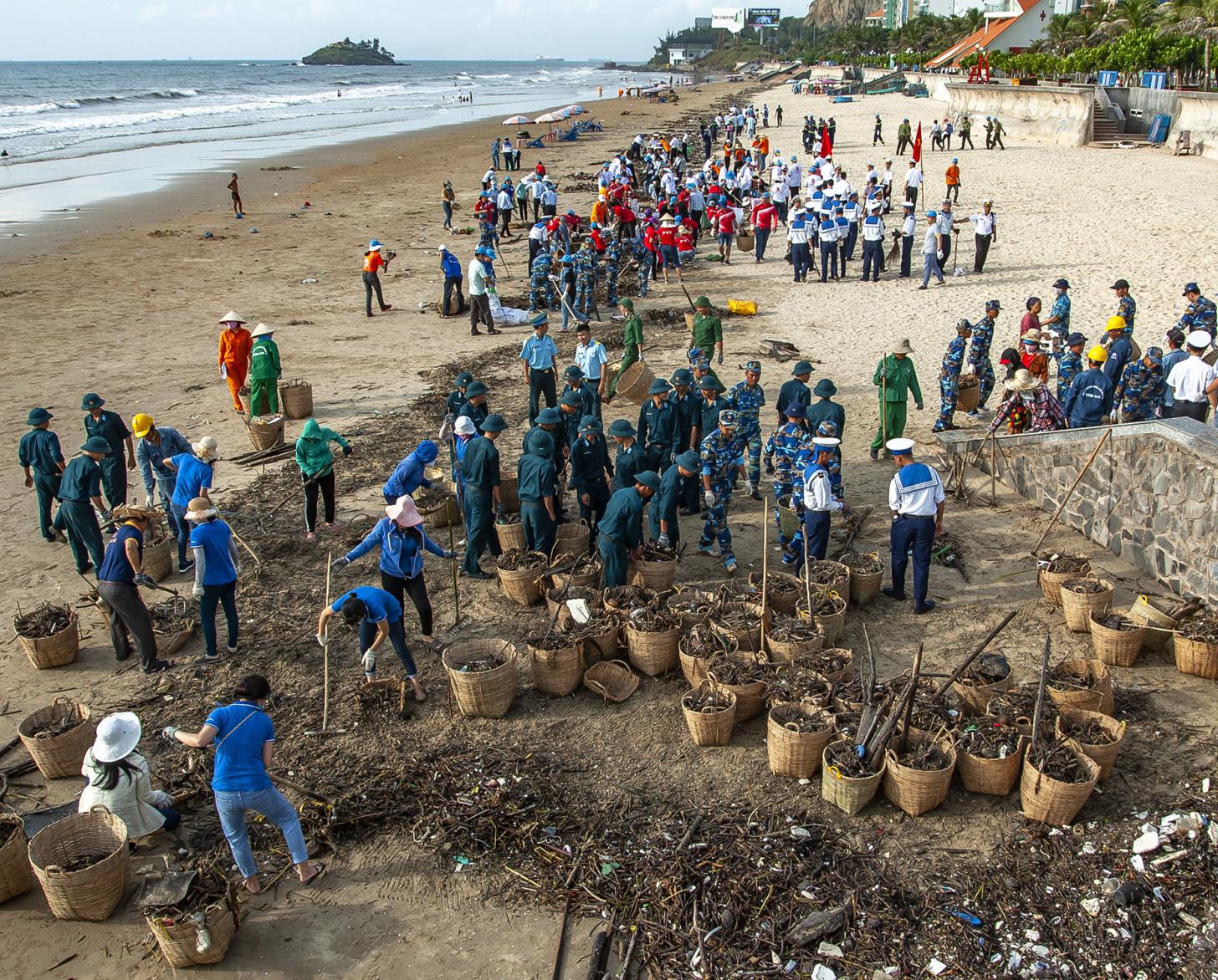أشخاص يعملون معًا لجمع القمامة التي تطفو من البحر.