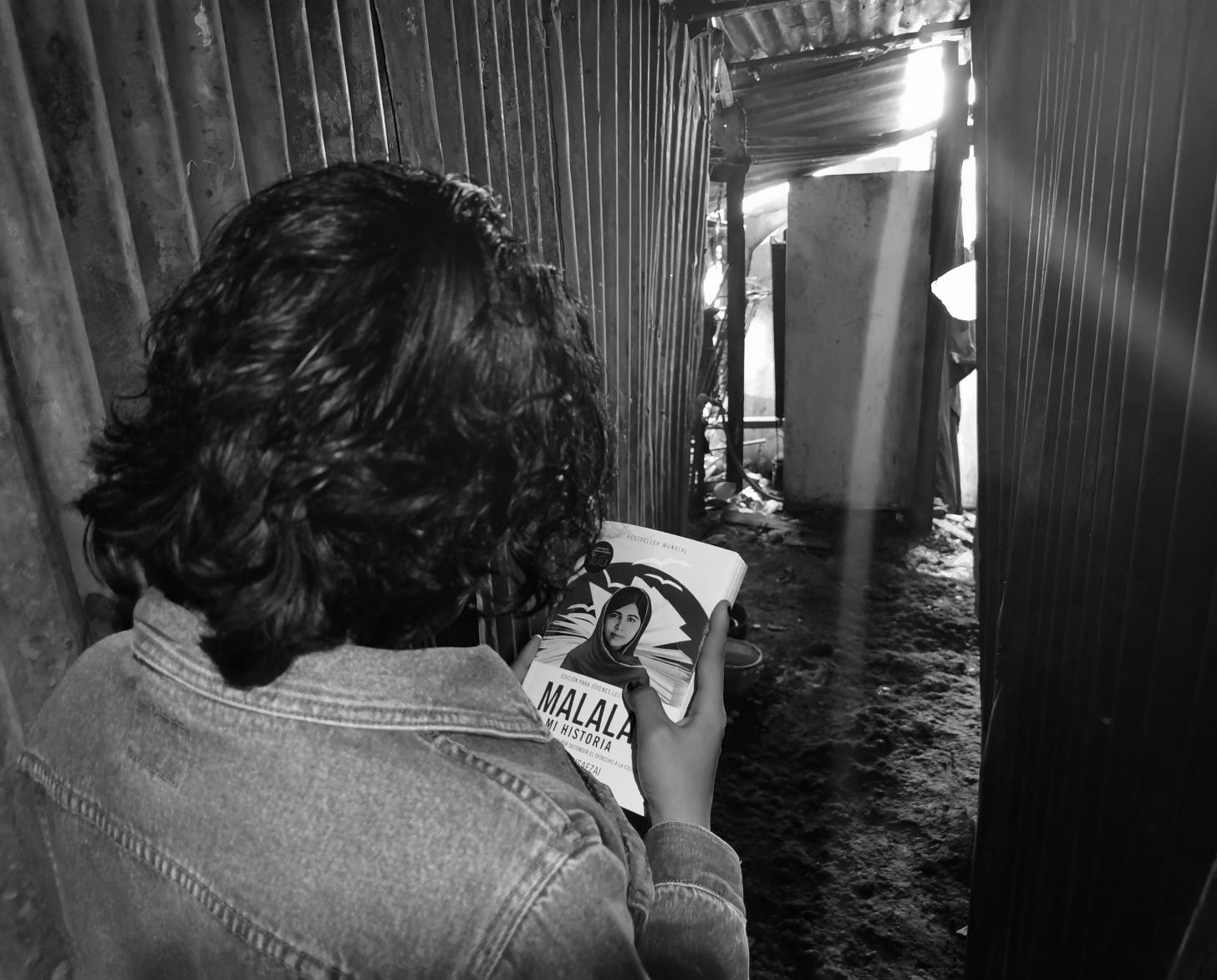 تبتعد ليليث عن الكاميرا وتحدق في كتاب ملالا الذي تحمله.