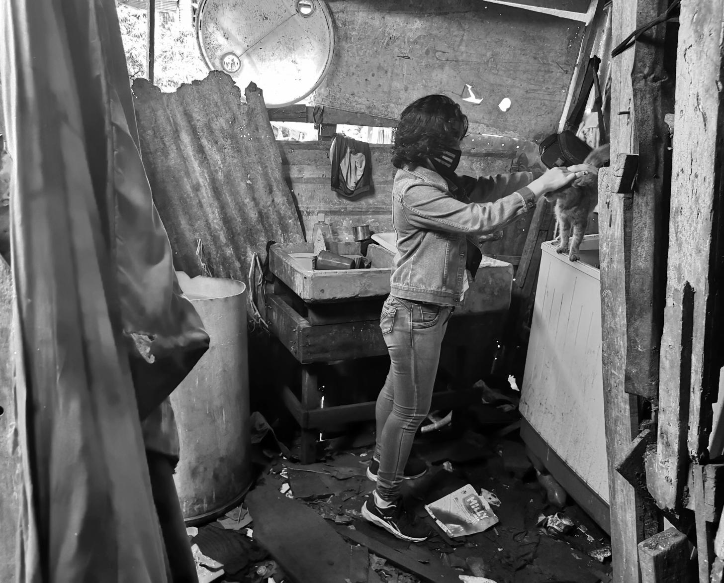 ليليث تقف في غرفة وتداعب قطتها بلطف.