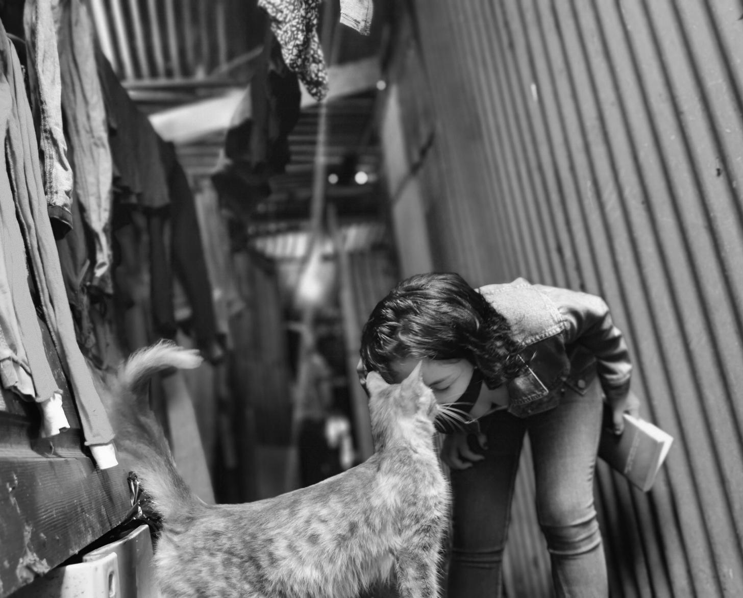 تنحني ليليث وتداعب قطتها بلطف.