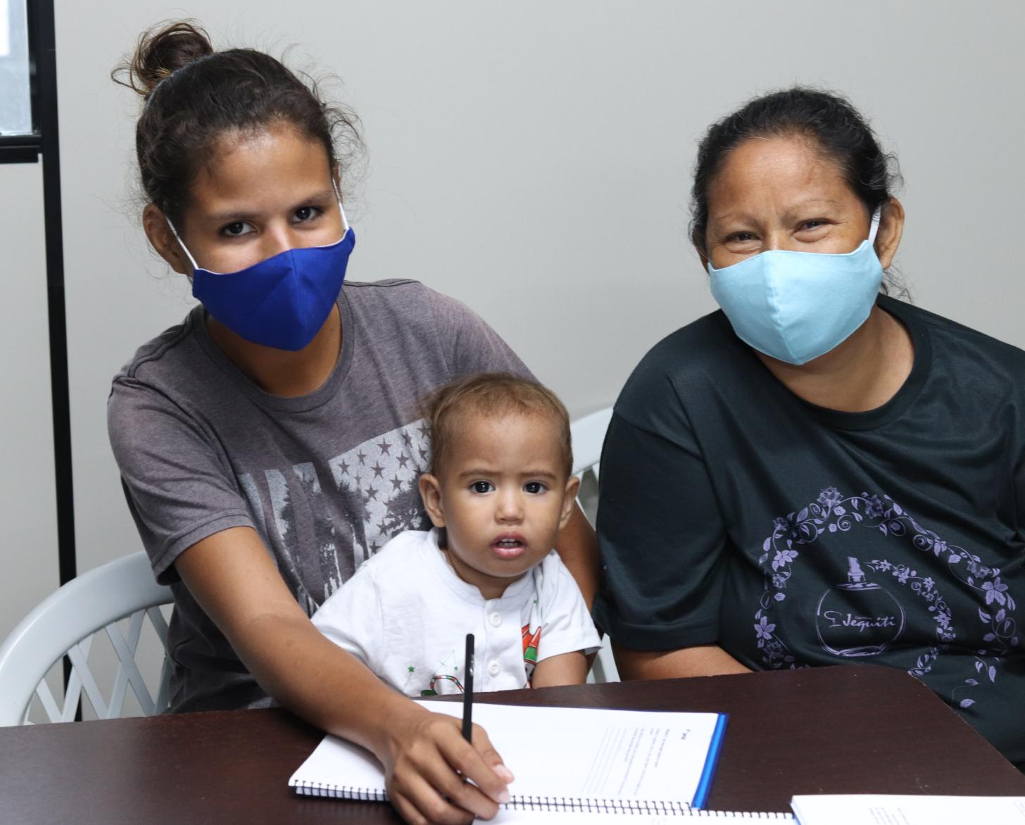 Dashly González, de 21 años, su madre y su hijo sonríen y se sientan juntos durante uno de los programas.