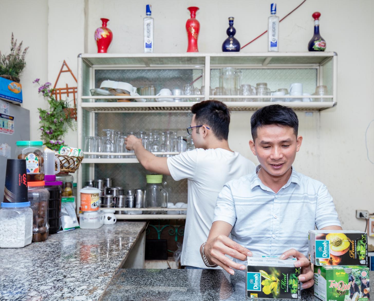 نجوين ترونج هونغ يقف عند منضدة المقهى الذي افتتحه كمساحة آمنة لمجتمع الميم في سون لا.