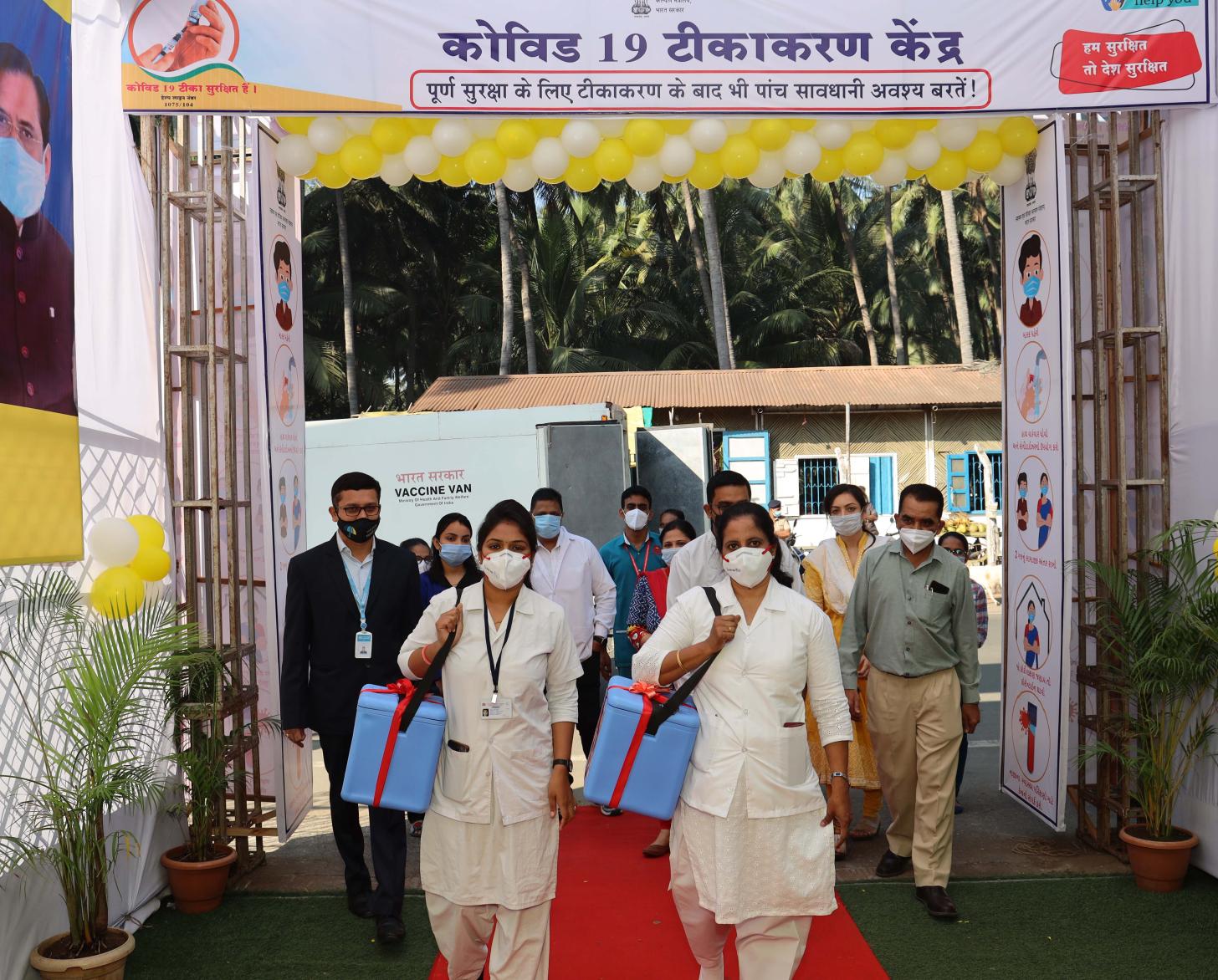 عاملتا رعاية صحية ترتديان كماكتين وتسيران نحو الكاميرا على سجادة حمراء.