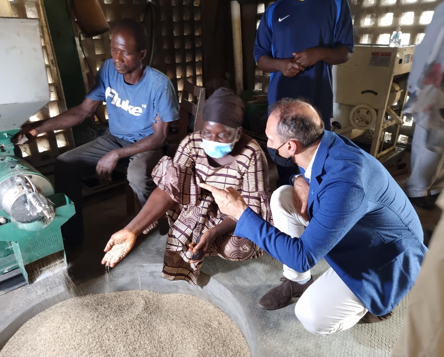 يركع المنسق المقيم فنسنت مارتن أمام سيدة من قادة المجتمع.