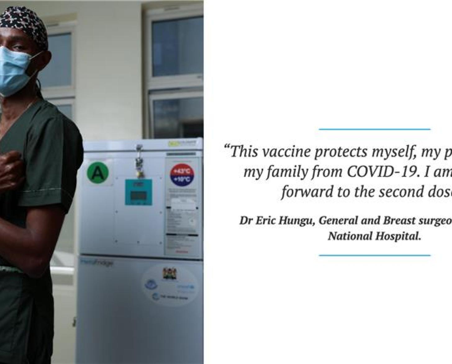 A man in green surgical scrubs and a blue face mask gives the camera thumbs up while crossing his arms in an x. 