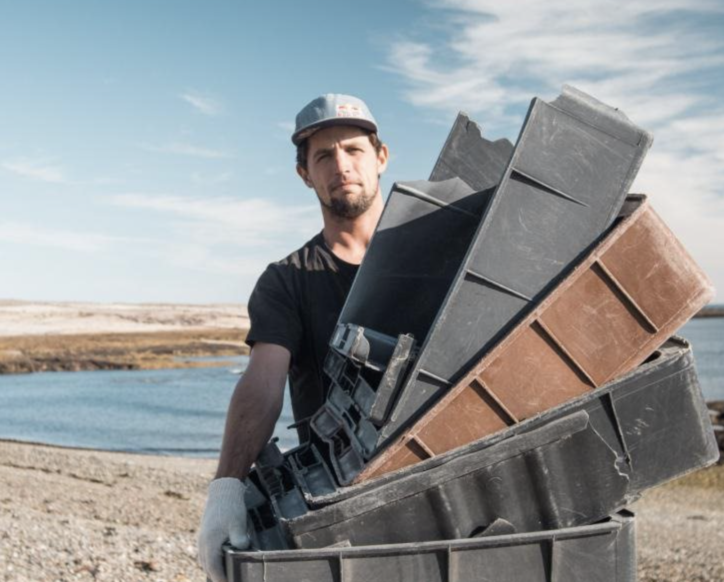 一个穿着黑色衬衫、戴着白色手套和帽子的人拿着塑料箱。