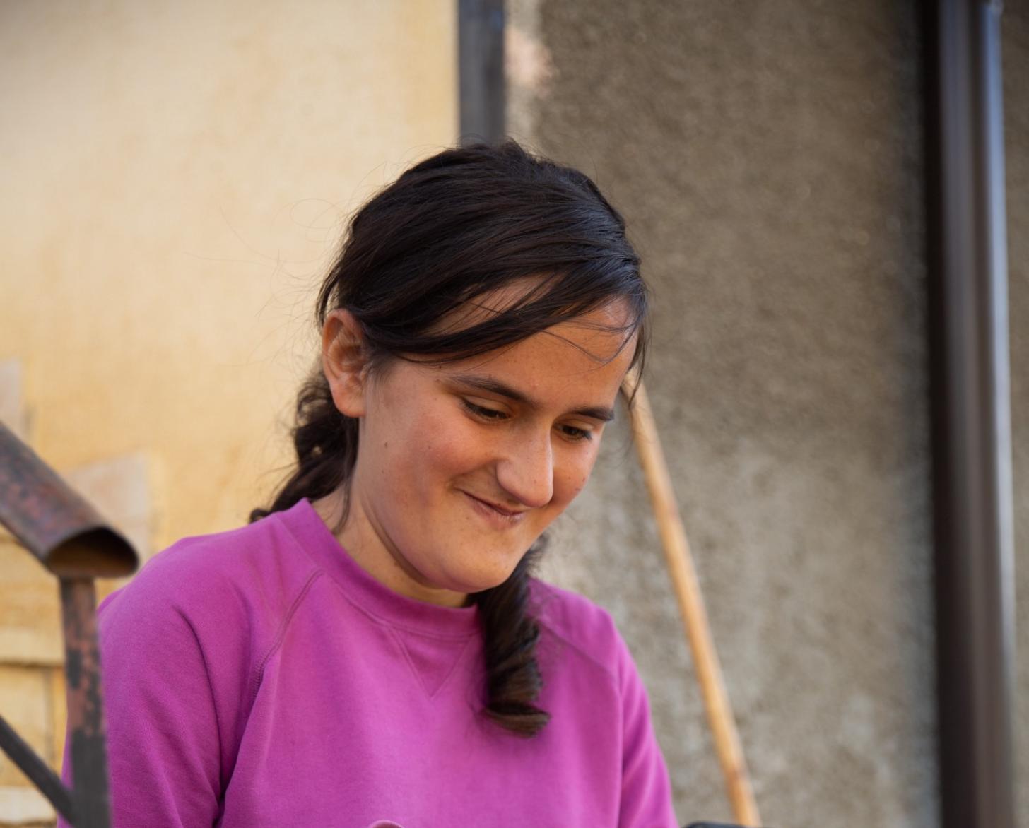 Una chica joven sonríe mientras mira la pantalla de un ipad.