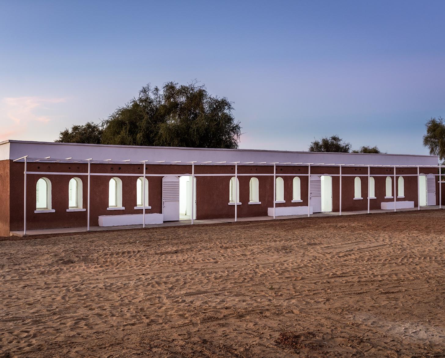 Un edificio con las luces encendidas al anochecer.