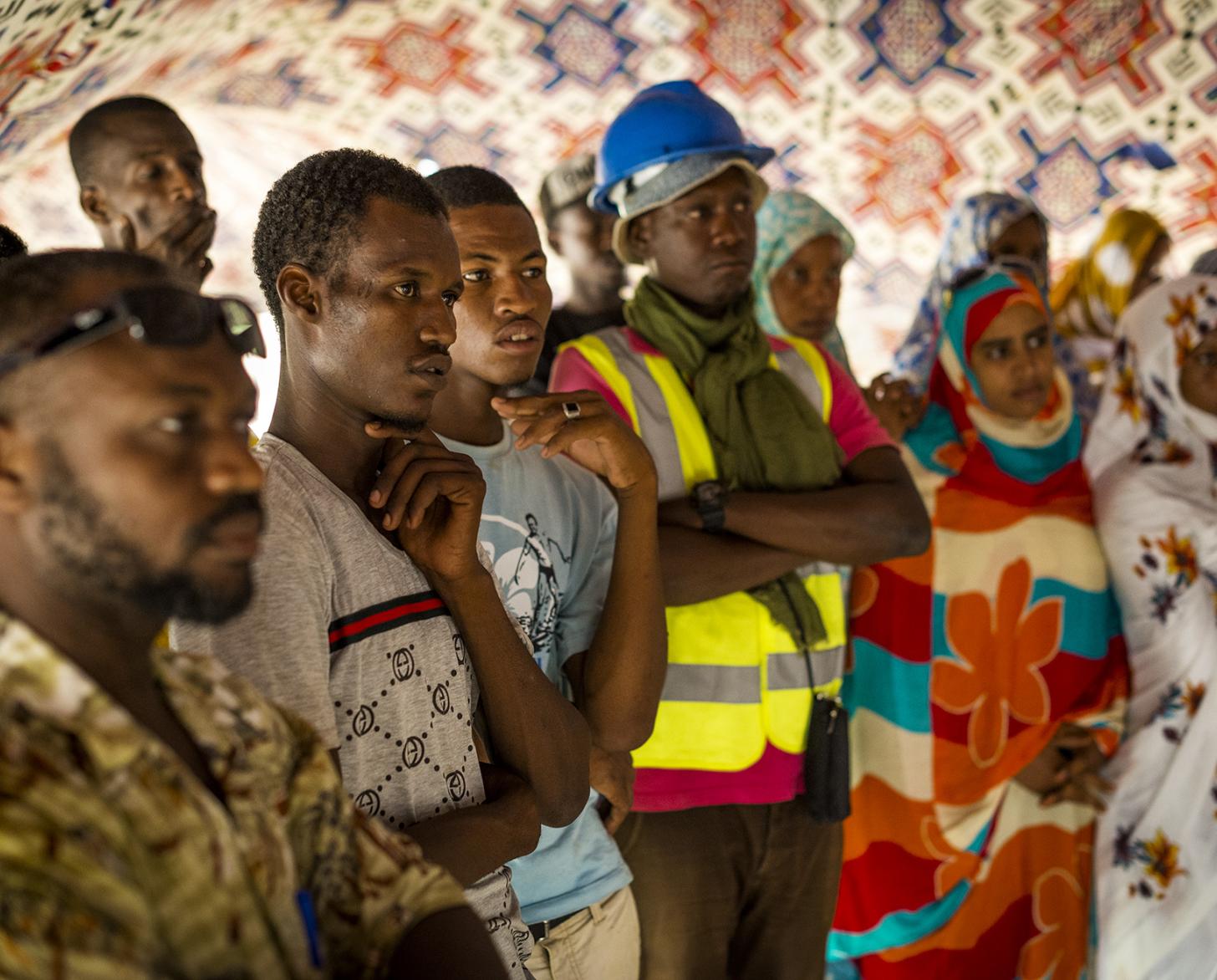 Un grupo de personas escucha atentamente a un orador que está fuera de cámara.