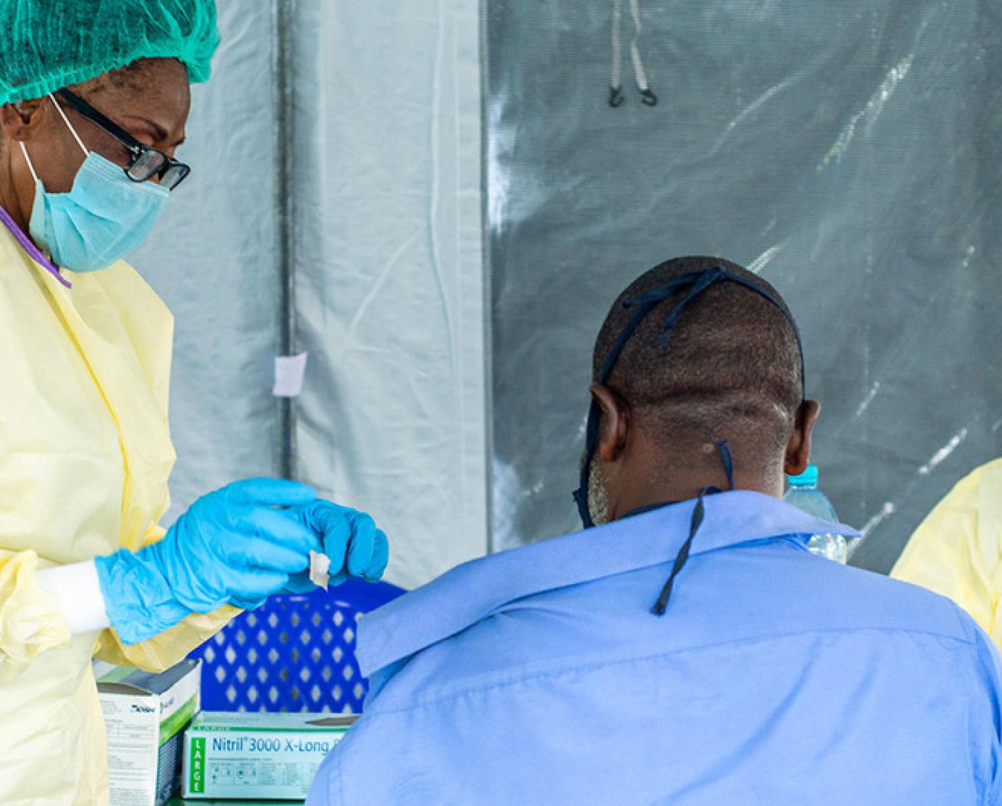 медсестры вводят вакцину мужчине.