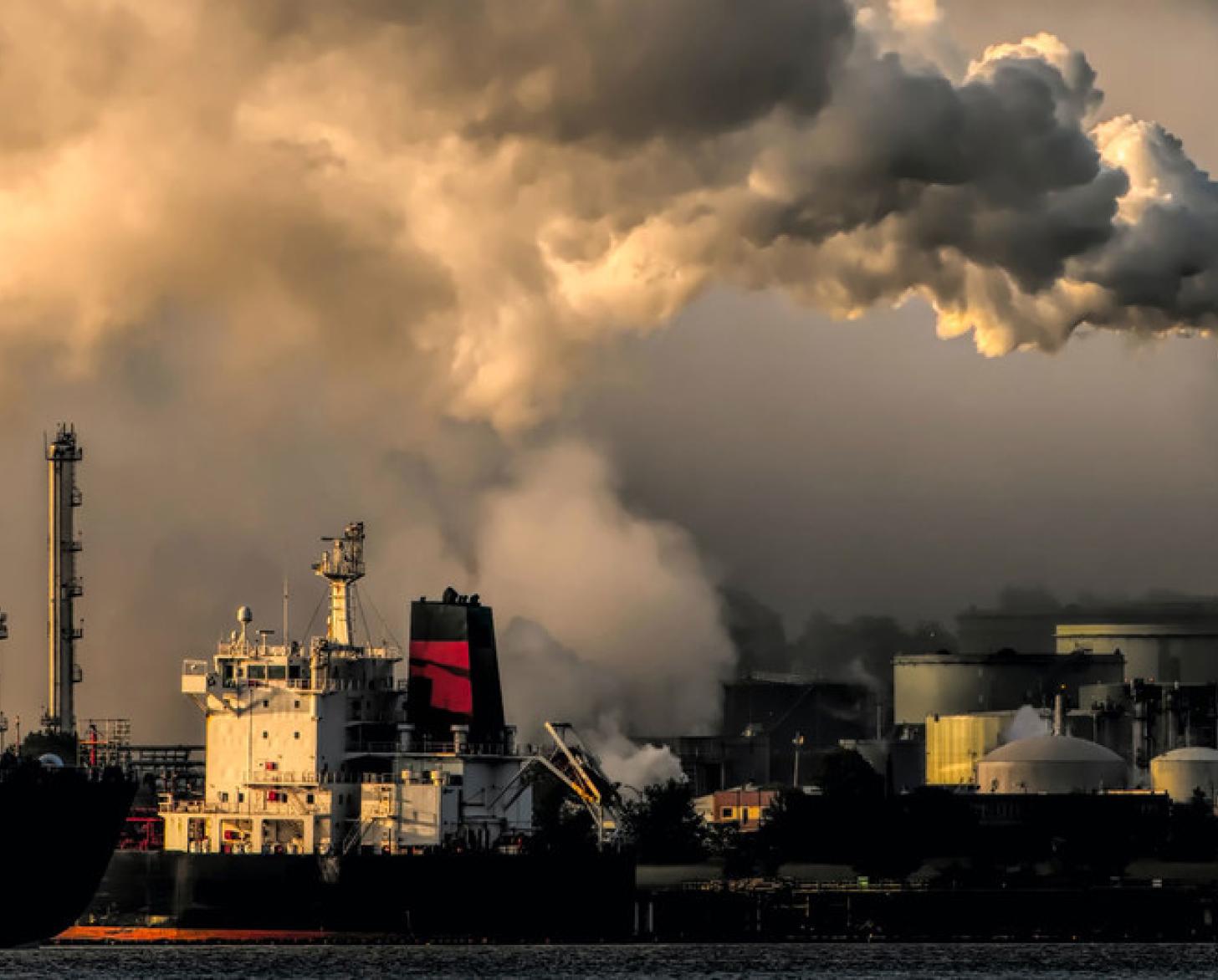 Vue d'une zone indsutrielle où l'on voit des usines rejeter des gaz polluants.
