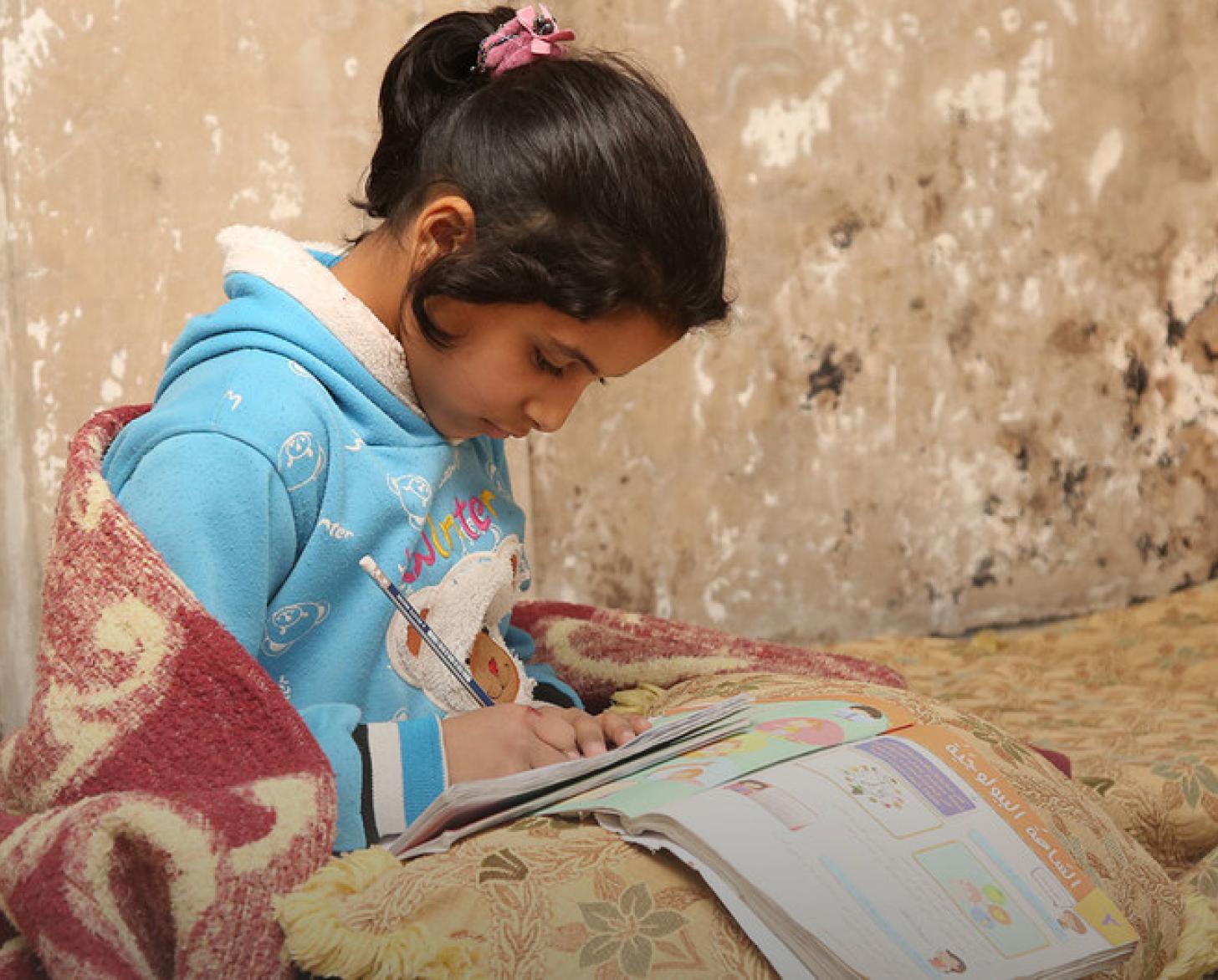 طفلة تجبس على الأرض لتدرس.