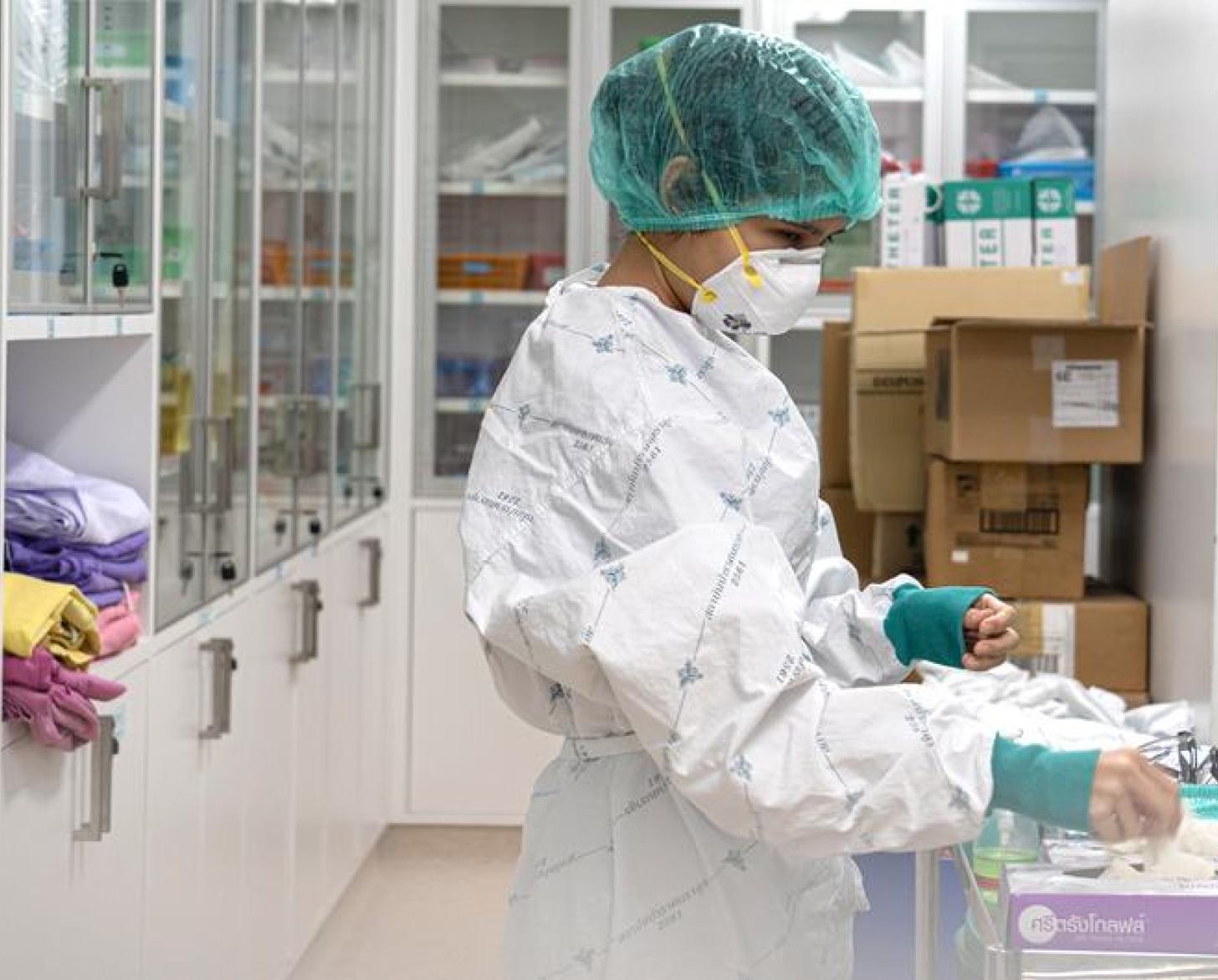 عاملة صحية في مختبر تقوم بارتداء القفازات.