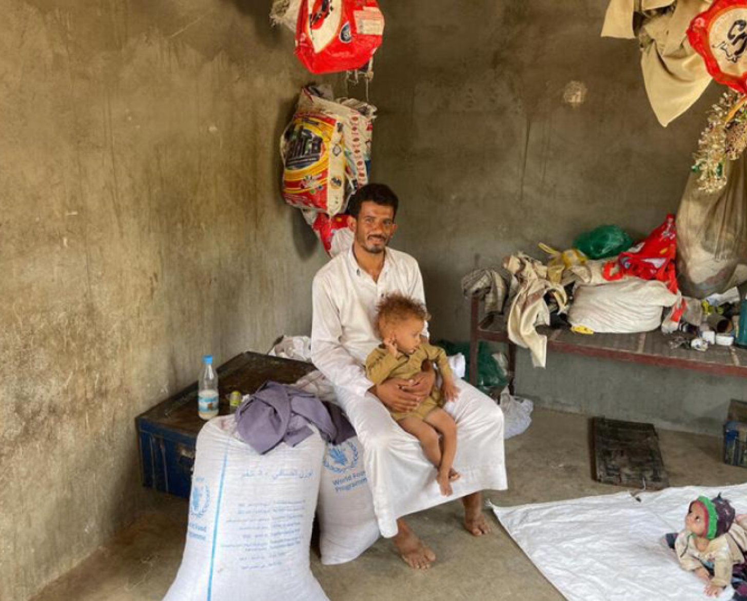 رجل يجلس مع طفليه ويبتسم.