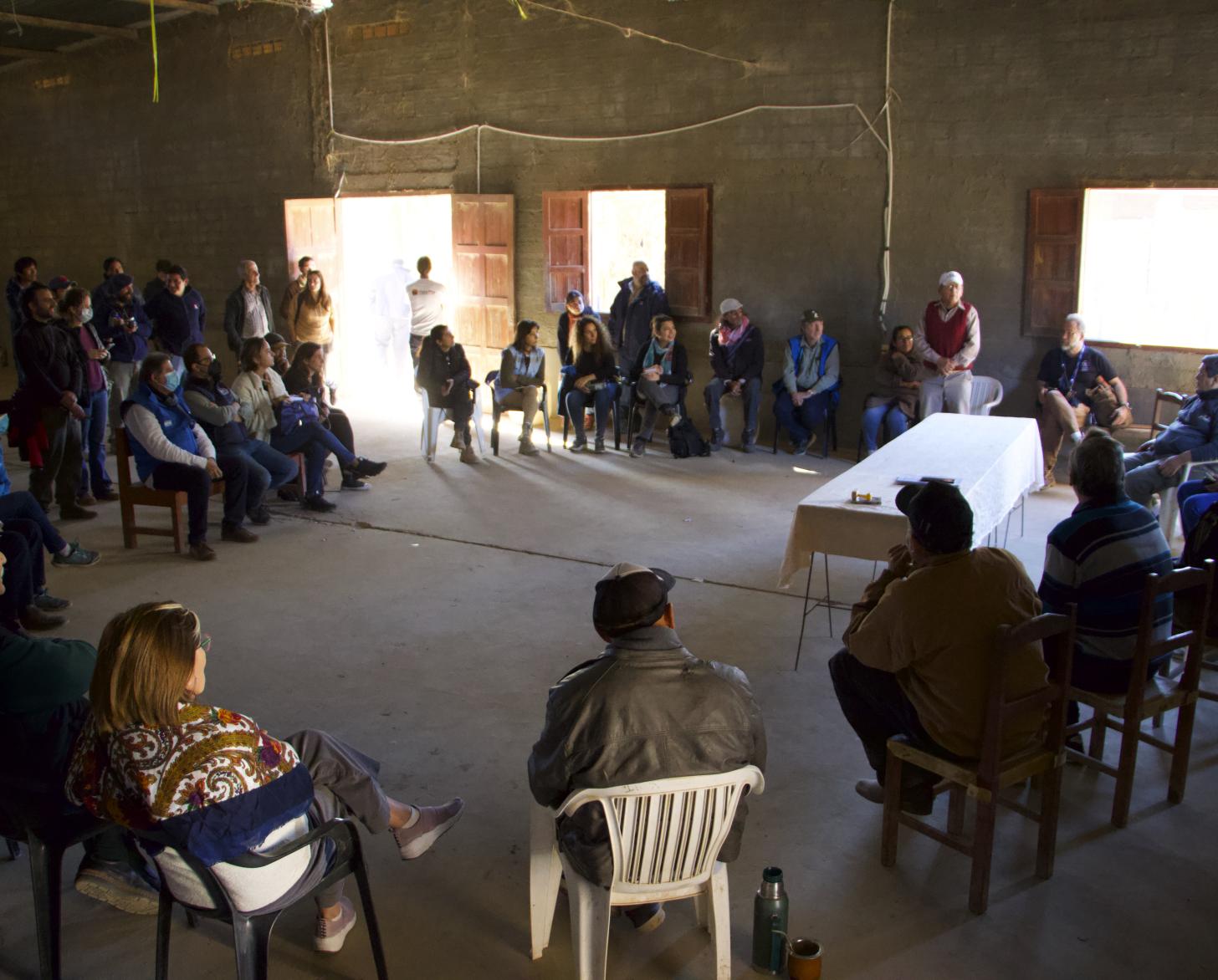 Un grupo de personas sentada en distribución circular en un espacio interior, ubicado en Santa Victoria Este, en Argentina.