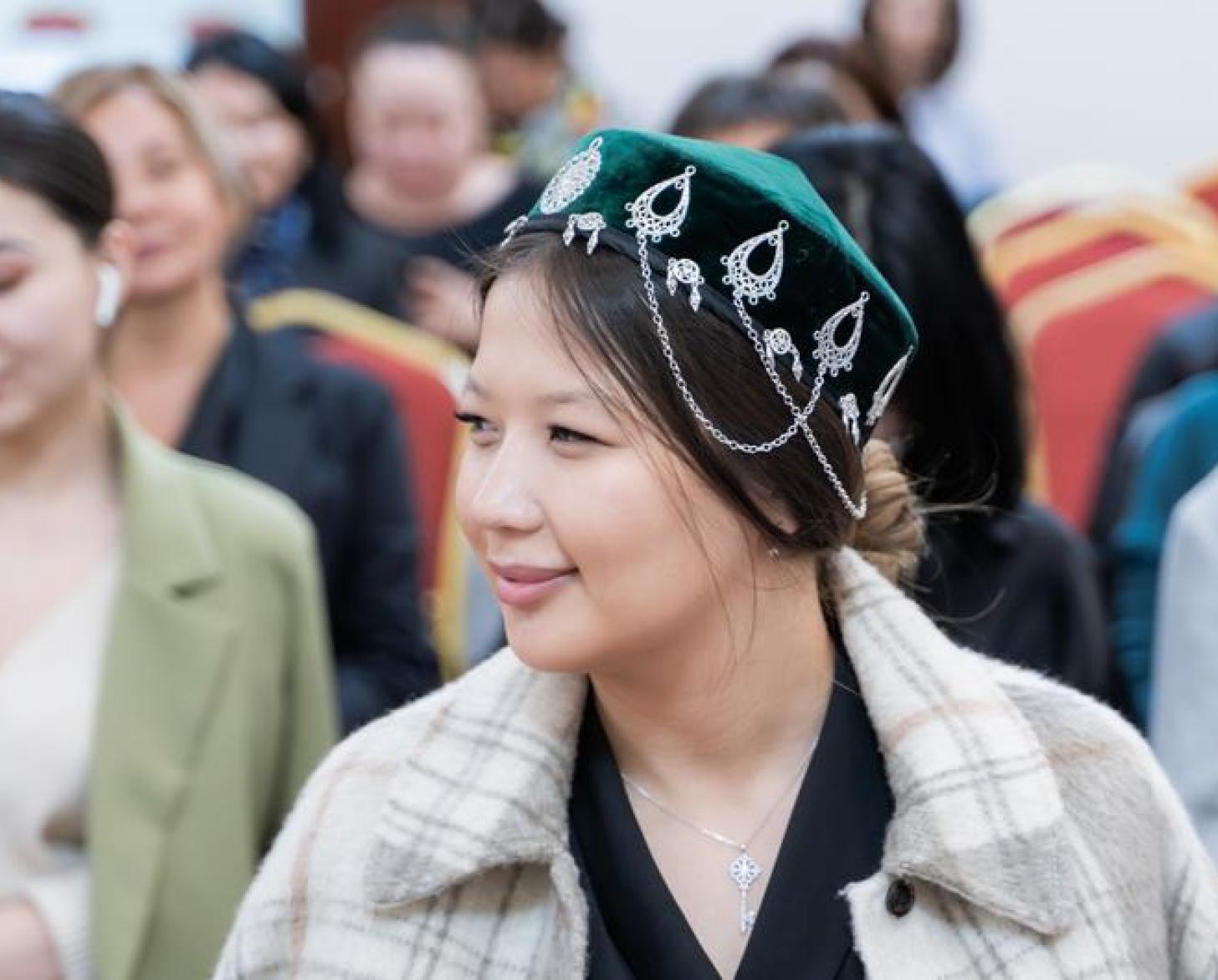 Close-up of a girl wearing a traditional Kazakh headdress.