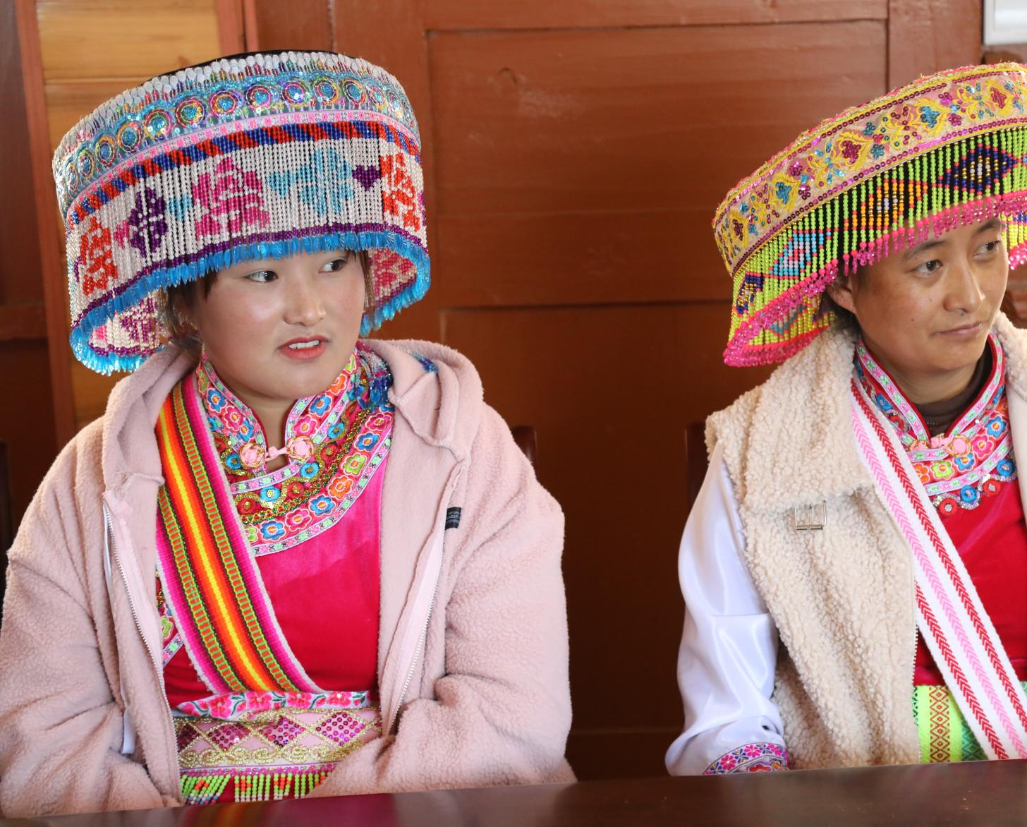 2名戴着彩色的头饰和服装的中国少数民族妇女