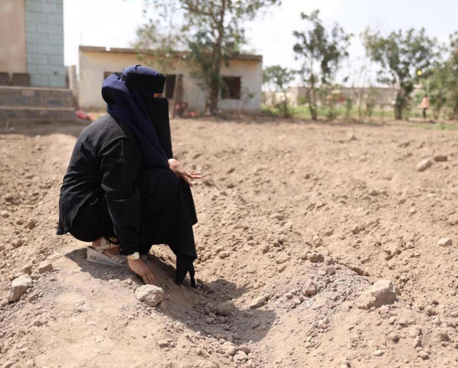 سيدة محجبة في حقل جاف.