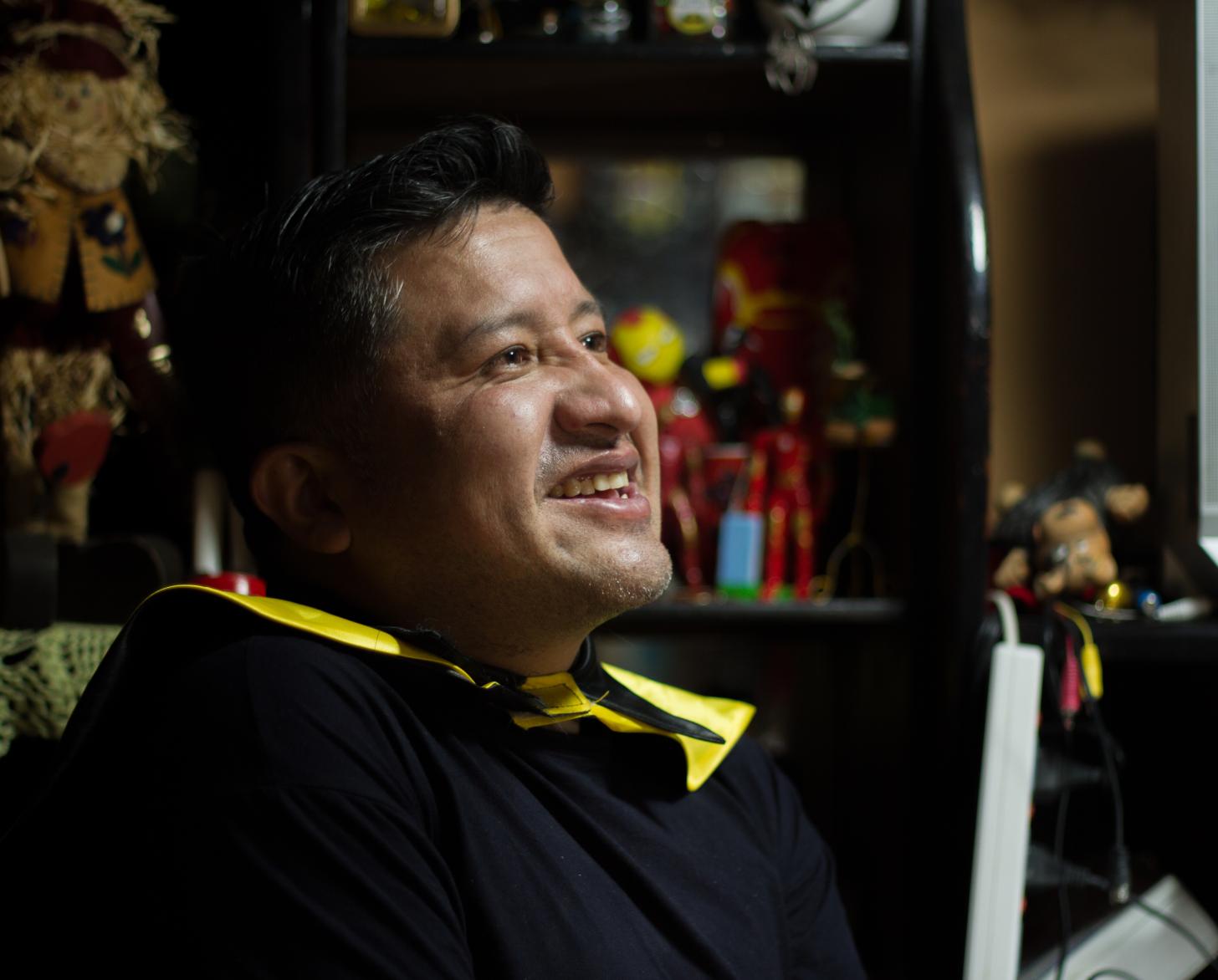 Primer plano del perfil de un hombre que sonríe mientras mira al frente.