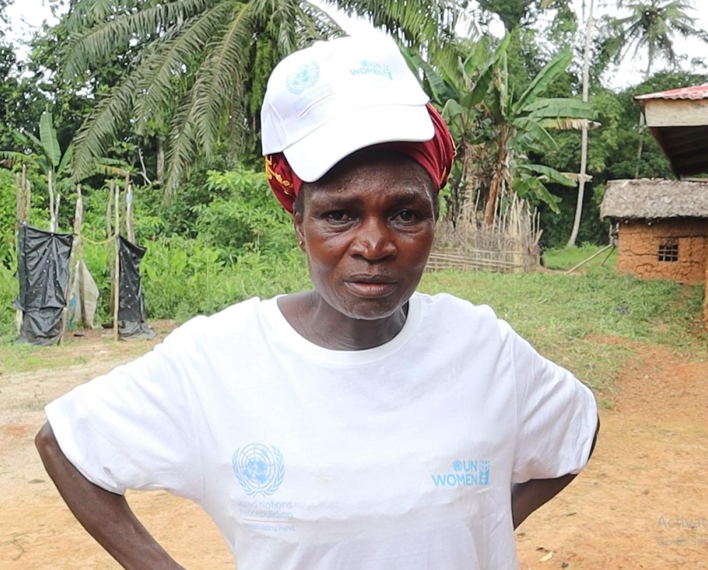 صورة لامرأة ترتدي قميصًا وقبعة بيضاء من هيئة الأمم المتحدة للمرأة وتنظر للكاميرا.